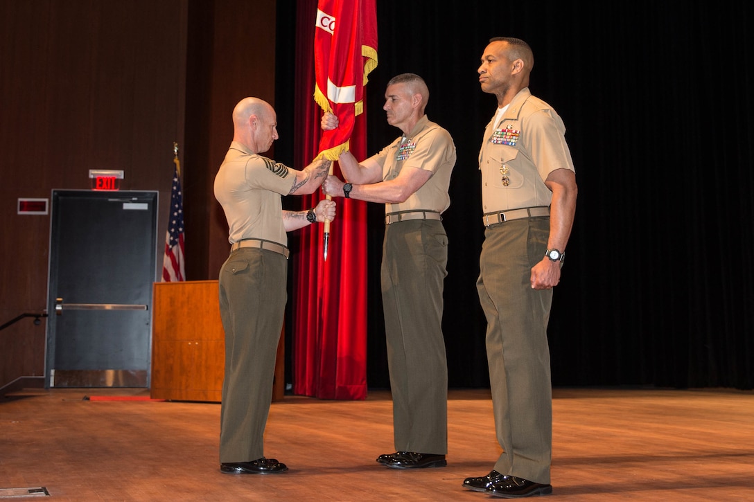 U.S. Marines Corps Sgt. Maj. Jeffery G. Mossen, sergeant major, Training Command, passes the colors to Brig. Gen. Jason Q. Bohm, outgoing commanding general (CG), Training Command, for the Training Command change of command at Warner Hall, Marine Corps Base Quantico, Va., May 18, 2018. Brig. Gen. Jason Q. Bohm, outgoing CG, Training Command, relinquished command to Col. Calvert Worth Jr., Brig. Gen. select, incoming CG, Training Command. (U.S. Marine Corps photo by Cpl. Brooke Deiters)