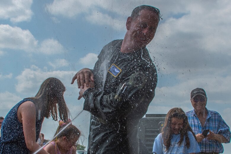U.S. Air Force Col. Christopher Anderson, vice commander of the 307th Bomb Wing, tries to avoid being sprayed with water by family and friends at Barksdale Air Force Base, Louisiana, June 1, 2018. Anderson had just completed his ‘fini flight’ which is a military aviator's last flight with his assigned unit or before retirement from the service. (U.S. Air Force photo by Airman Maxwell Daigle/Released)