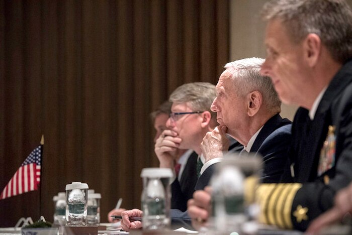 Defense Secretary James N. Mattis sits at a table with others.