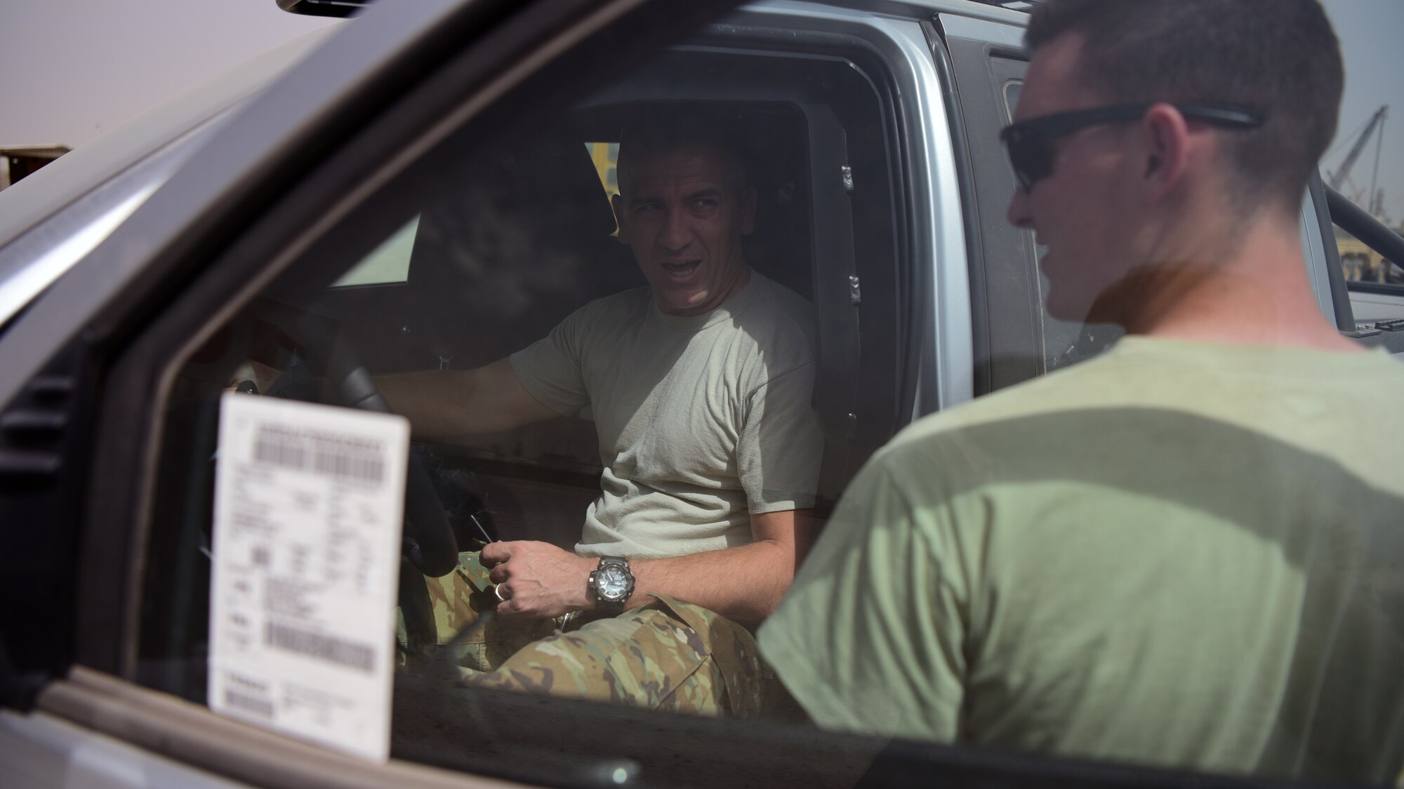 Master Sgt. Travis Eldridge, 386th Expeditionary Logistics Readiness Squadron traffic management office superintendent, speaks to Senior Airman Matthew Koch, 386th ELRS inbound cargo technician, May 28, 2018, at an undisclosed location in Southwest Asia. Eldridge, Koch and the TMO team inspected vehicles prior to delivering them to their final destination, where they will be used to support Operation Inherent Resolve. (U.S. Air Force photo by Staff Sgt. Christopher Stoltz)
