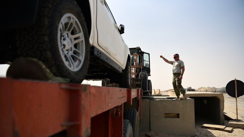Master Sgt. Travis Eldridge, 386th Expeditionary Logistics Readiness Squadron traffic management office superintendent, helps off-load a vehicle from a tractor trailer May 28, 2018, at an undisclosed location in Southwest Asia. The traffic management office here is responsible for the safe transport and delivery of equipment and assets throughout the U.S. Central Command area of responsibility. (U.S. Air Force photo by Staff Sgt. Christopher Stoltz)