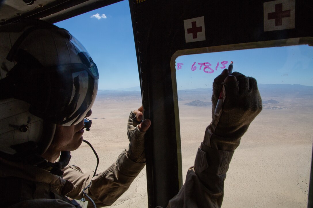 A doorgunner with Light Attack Helicopter Squadron 367, also known as ‘Scarface’, writes down grid coordinates while on a flight mission during the Final Exercise of Integrated Training Exercise 3-18 aboard the Marine Corps Air Ground Combat Center, Twentynine Palms, Calif., May 23, 2018. Marine aviation provides the Marines of the Marine Air Ground Task Force the operational flexibility it needs to accomplish their mission. (U.S. Marine Corps photo by Lance Cpl. Dave Flores)