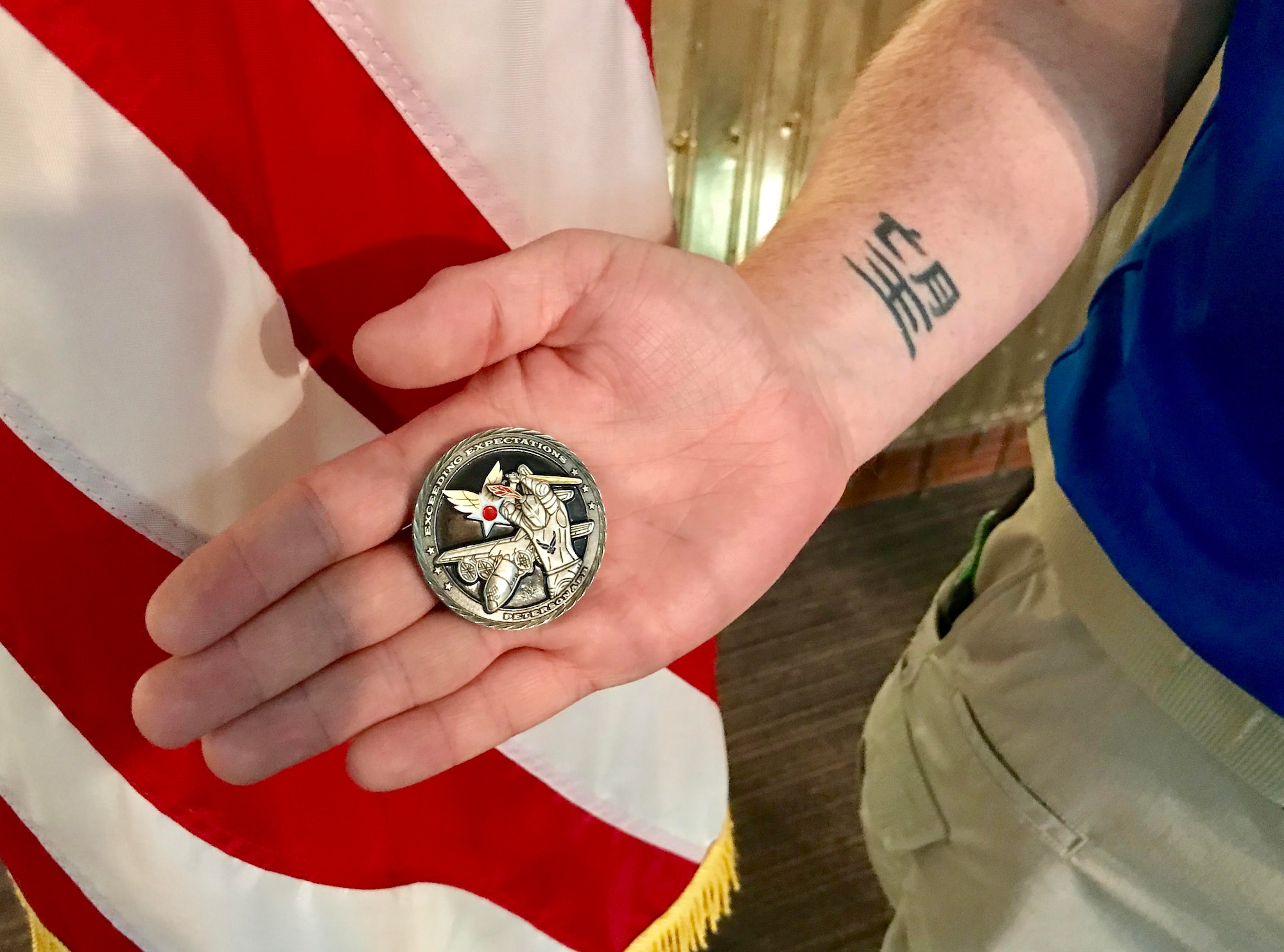 U.S. Air Force retired Staff Sgt. Cory Sandoval displays his coin, presented by Lt. Col. Summer Lewis, 21st Force Support Squadron commander, following a commander’s call at Peterson Air Force Base, Colorado, June 4, 2018. Lewis presented Sandoval with her coin after he shared his story with the squadron and shared how the Air Force Wounded Warrior Program saved his life following a tragic accident several years ago. (U.S. Air Force photo by Alexx Pons)