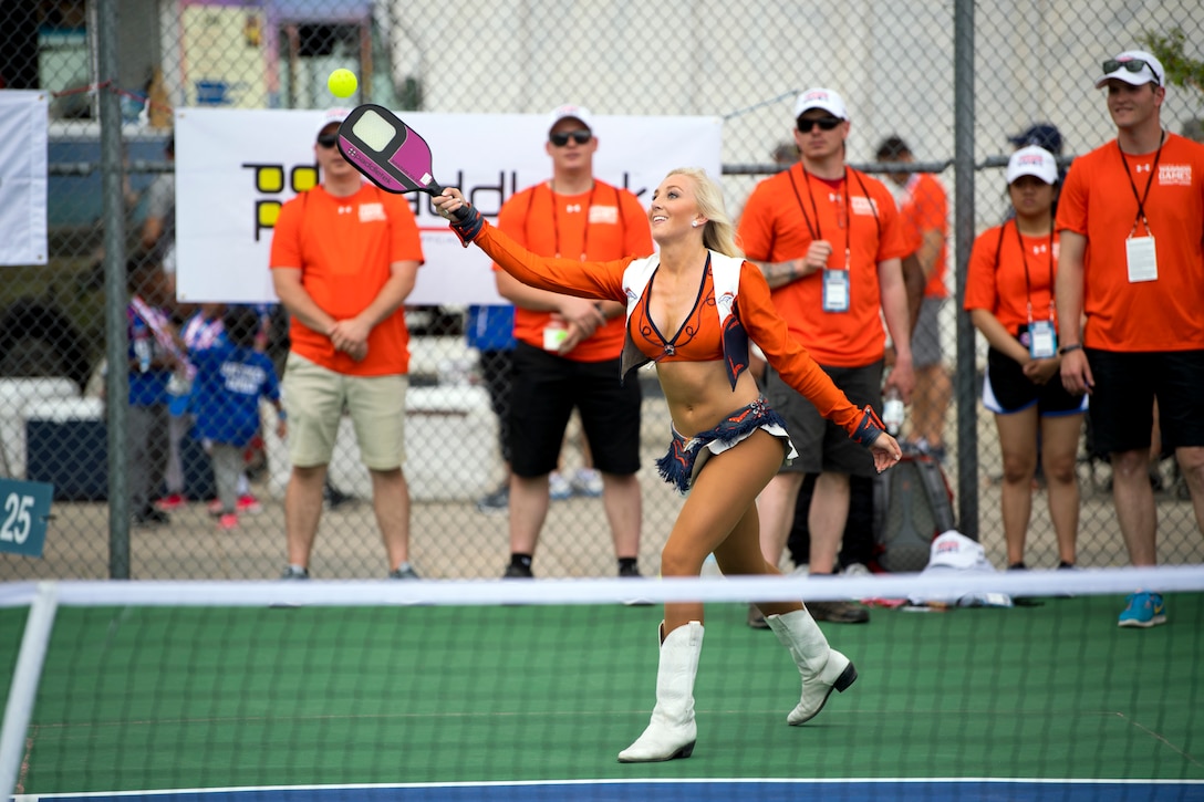 A cheerleader plays pickleball during an exhibition day.