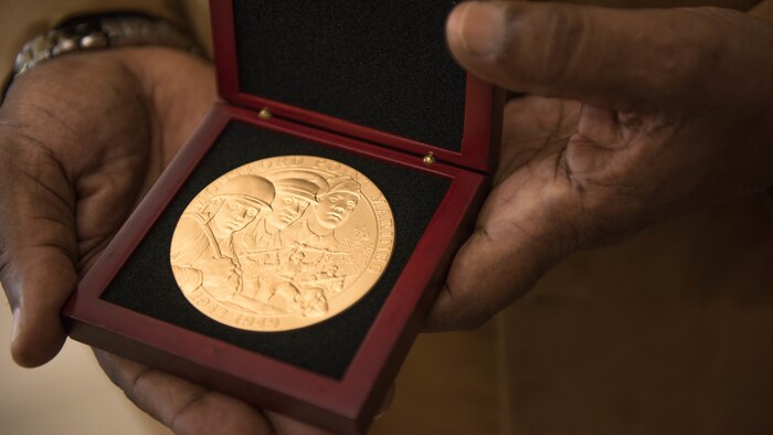 Clement E. Hill holds the Congressional Gold Medal posthumously awarded to his father Pfc. Burnie W. Hill, a Montford Point Marine May 31, 2018 at MacDill Air Force Base, Florida. In 1942, African Americans were given the opportunity to enlist in the United States Marine Corps. Nearly 20,000 African Americans from 1942-1949 were trained separately from their white counterparts at Montford Point, a facility at Camp Lejeune, North Carolina.