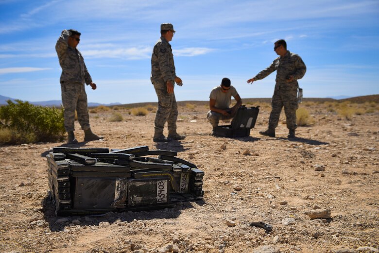 99th Civil Engineer Squadron explosive ordnance disposal technicians prepare a crate of flares for detonation during an ammunition disposition request at Nellis Air Force Base, Nevada, May 31, 2018. EOD technicians placed C4 around the crate to ensure every component was completely destroyed. (U.S. Air Force photo by Airman 1st Class Andrew D. Sarver)