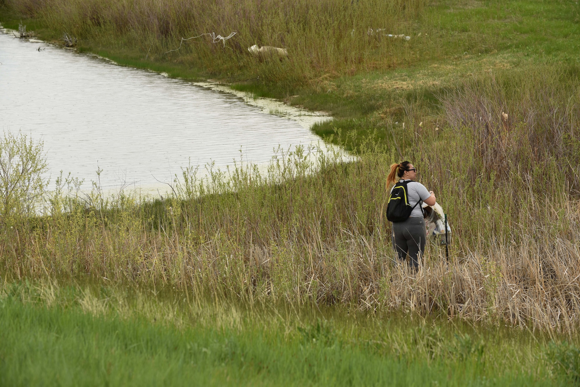 Nicole Ng, 90th Civil Engineering Squadron water program manager, collects trash around Gate 2 during the 2nd Annual Stream Cleanup on May 24, 2018, at F.E Warren Air Force Base, Wyo. Ng, the organizer of the stream cleanup aims for it become a bi-weekly event to help tidy up around the base. (U.S. Air Force photo by Airman 1st Class Abbigayle Wagner)