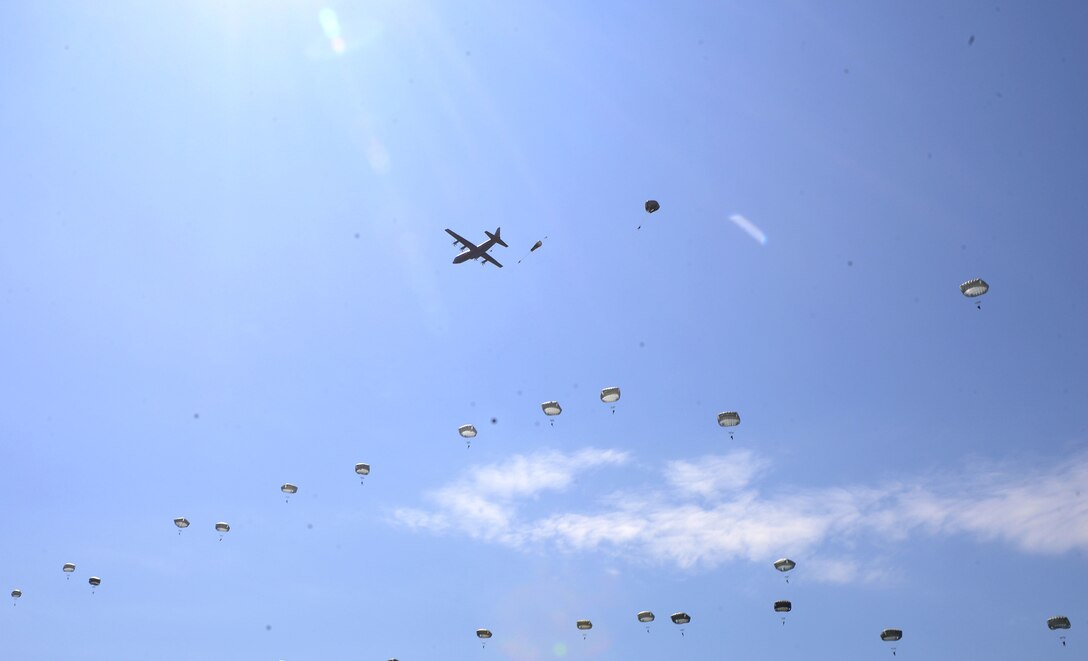 A U.S. Air Force C-130J Super Hercules drops paratroopers over Sainte-Mère-Église, France
