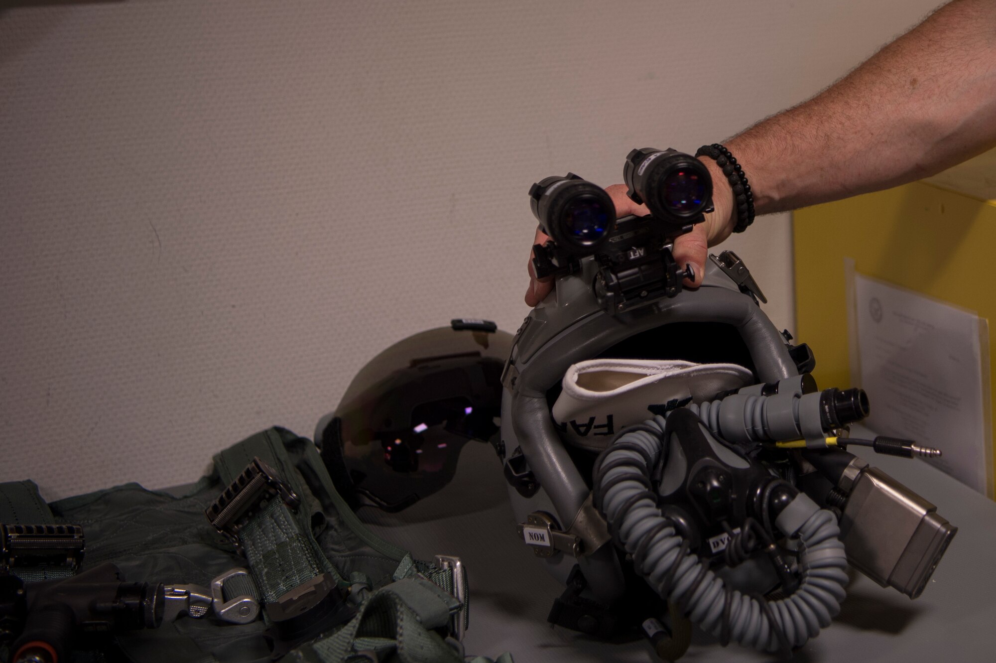 A pilot's F-16 helmet includes mounted night vision goggles that allow pilots to see in low light situations.