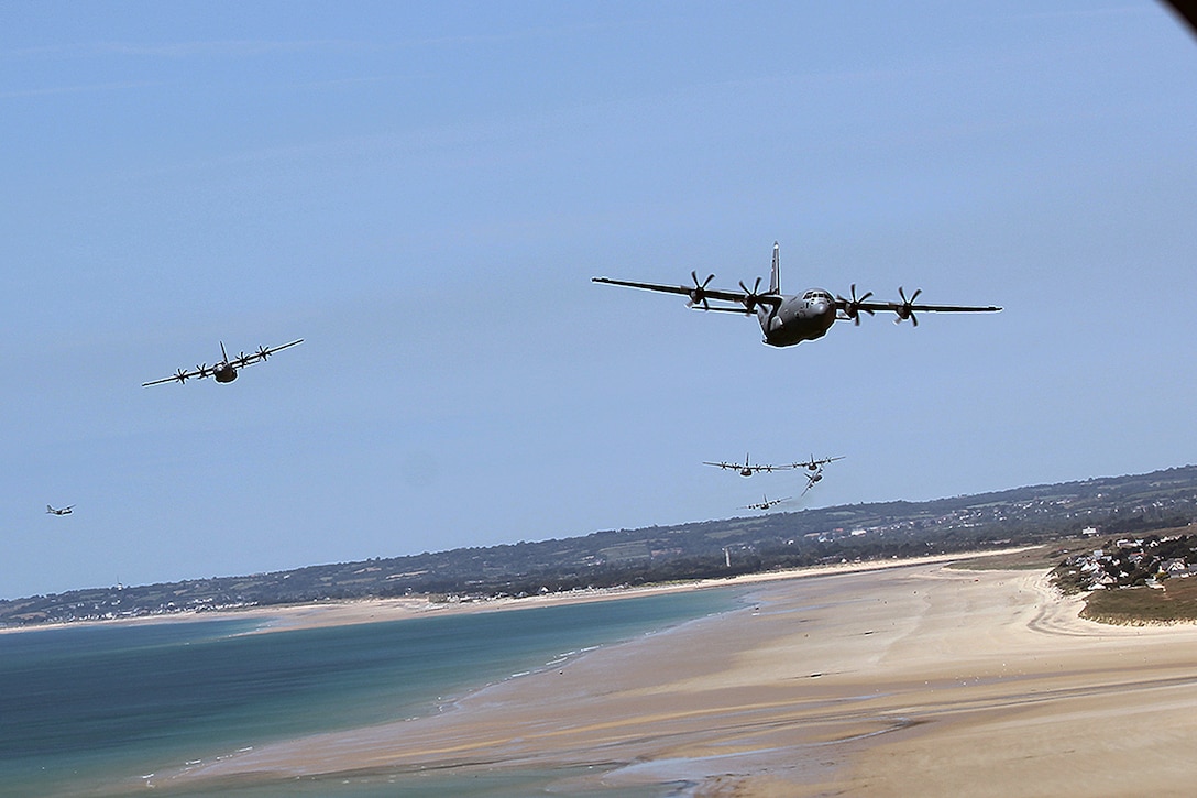 A-10 Thunderbolt II aircraft from the 107th Fighter Squadron, Michigan Air National Guard, are joined by a C-130 Hercules aircraft as they fly over the beaches of Normandy, France.
