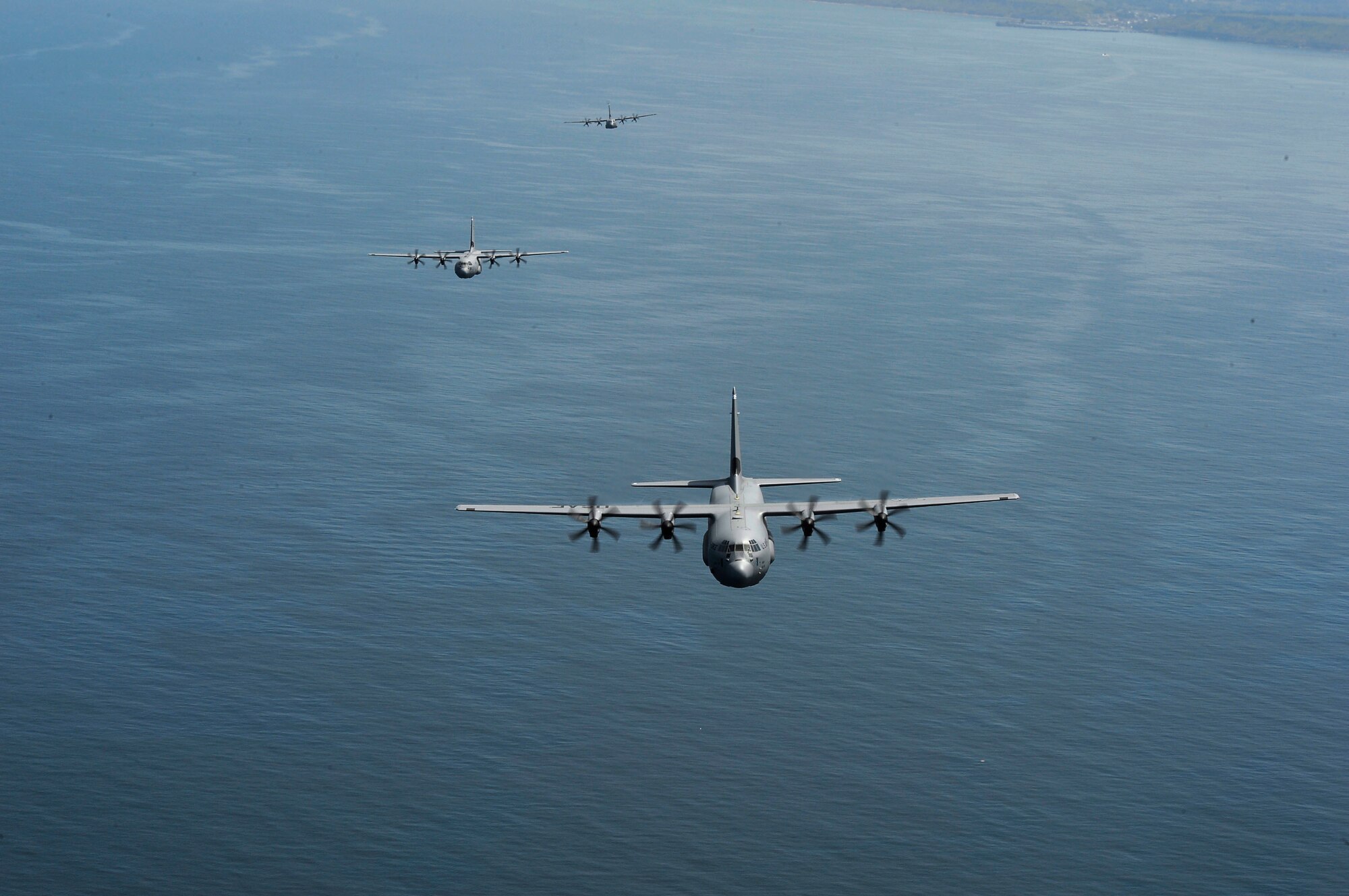 A formation of C-130J Super Hercules assigned to the 37th Airlift Squadron flies over the English Channel June 2, 2018. The 37th AS is a descendant unit of the 37th Troop Carrier Squadron, which dropped paratroopers over Normany on D-Day. (U.S. Air Force photo by Senior Airman Joshua Magbanua)