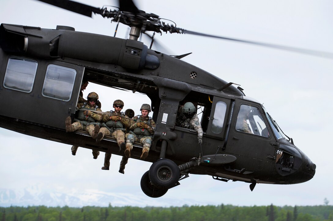 Airmen and soldiers take off in a UH-60 Black Hawk helicopter.