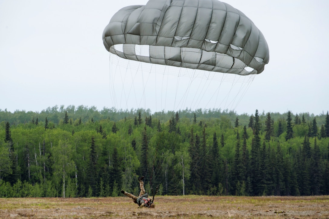 An airman performs a parachute landing fall after conducting airborne operation.