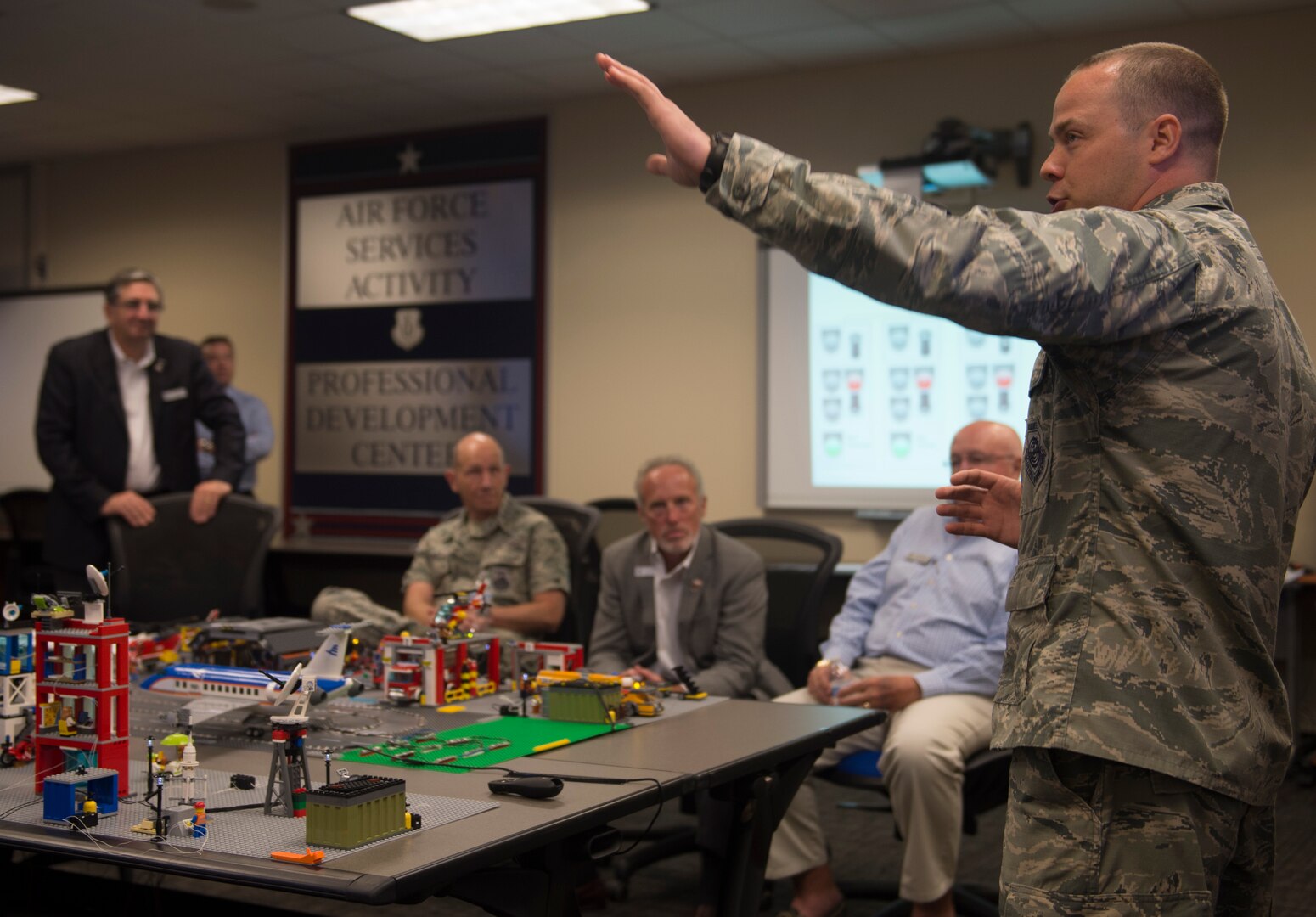 Capt. Justin Ball, 390th Cyberspace Operations Squadron Weapons and Tactics chief, explains the purpose of the 90th Cyber Operations Squadron “Bricks-in-the-Loop” model to Gen. Mike Holmes, commander Air Combat Command, and civic leaders during a tour at Joint Base San Antonio-Lackland, Texas, May 31, 2018. The model is used as a cyber training tool to teach cyber Airmen information technology and operational technology network defense. The tour was hosted to introduce attendees to 24th Air Force's cyberspace mission and 25th AF's intelligence, surveillance and reconnaissance mission. (U.S. Air Force photo by Tech. Sgt. R.J. Biermann)