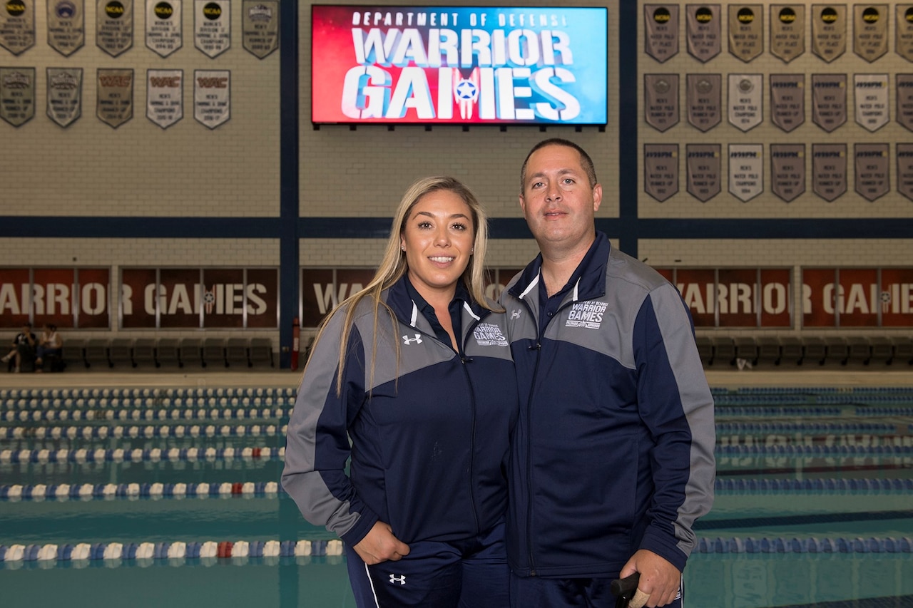 Medically retired Navy Petty Officer 3rd Class Anthony Diele and his wife, Carolina, pose for a photo by the 2018 Defense Department Warrior Games competition pool at the U.S. Air Force Academy in Colorado Springs, Colo. June 4, 2018. DoD photo by EJ Hersom