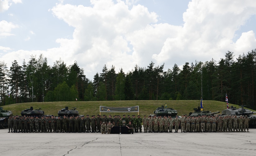 Tank platoons, from eight NATO and partner nations pose together for a photo