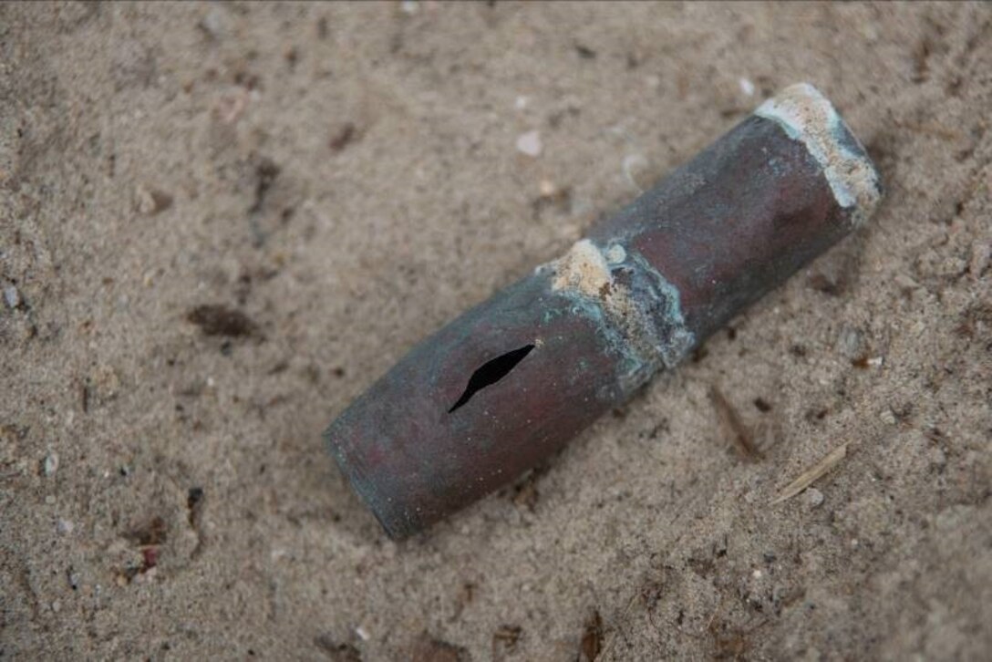 A rusted round rests on Onslow beach after being washed ashore. According to the base’s Brown’s Island Policy,