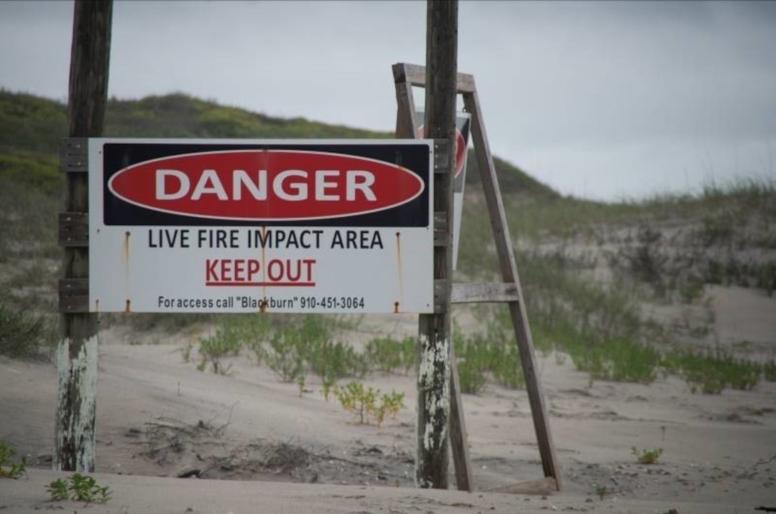 Danger signs stand along the border of Browns Island to warn beach goers not to walk into the impact area.
