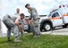 Staff Sgt. Zachary Conn, military working dog handler with the 319th Security Forces Squadron, left, rinses his face after completing a training course which required him to be sprayed in the face with oleoresin capsicum May 29, 2018, on Grand Forks Air Force Base, North Dakota. After being sprayed with OC spray, Conn and the other training participants had to practice taking out, spraying and holstering simulated OC spray, hitting a target with their baton and handcuffing a simulated perpetrator.   (U.S. Air Force photo by Airman 1st Class Elora J. Martinez)