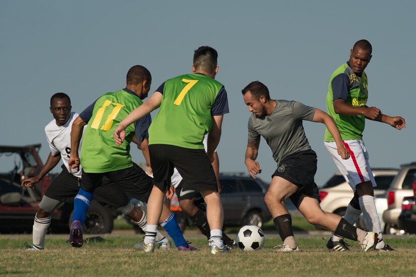 A member of the 633rd Medical Group team dribbles the ball through members of the 735th Supply Chain Operations Group team during the Intramural Soccer Championship at Joint Base Langley-Eustis, Virginia, June 4, 2018.