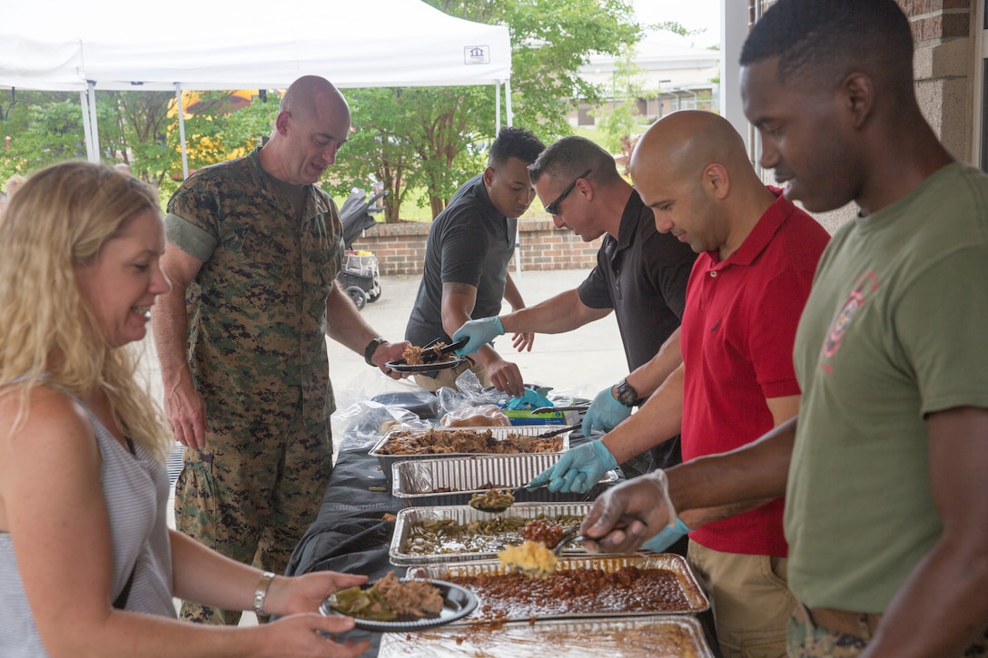 Volunteer service members serve food during a room dedication ceremony at Wounded Warrior Battalion - East on Marine Corps Base Camp Lejeune, May 24.