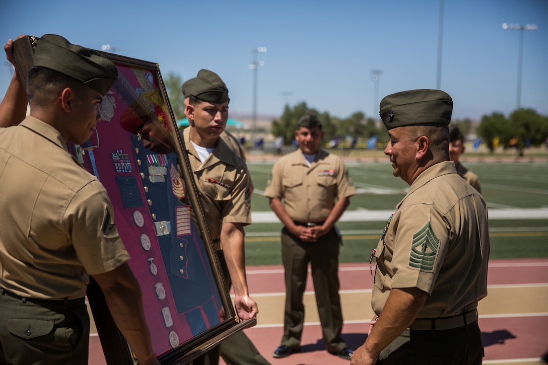 Master Gunnery Sgt. Joseph Lopez, supply chain administration and operations specialist, Headquarters Battalion, is presented a parting gift during his retirement ceremony at Felix Field aboard the Marine Corps Air Ground Combat Center, Twentynine Palms, Calif., June 1, 2018. Lopez is retiring after 30 years of faithful service to country and Corps. (U.S. Marine Corps photo by Lance Cpl. Isaac Cantrell)