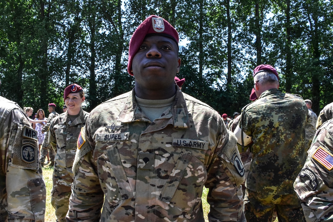 Army Specialist Supel stands at attention as German jumpmasters awards him German Jump wings.