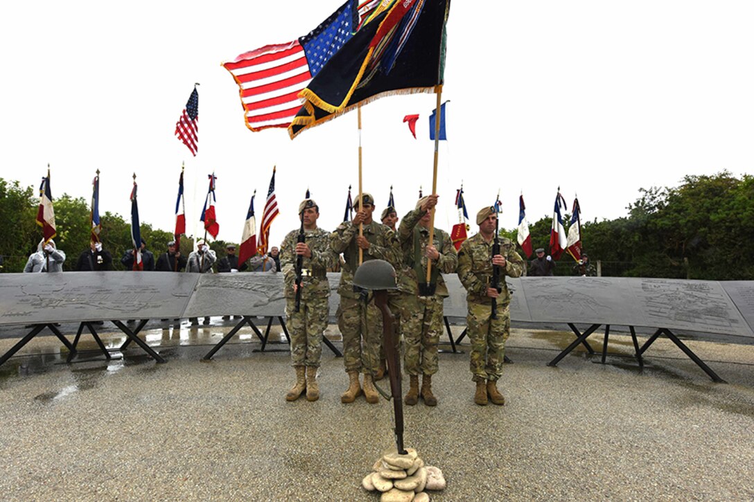Soldiers hold flags for a ceremony.
