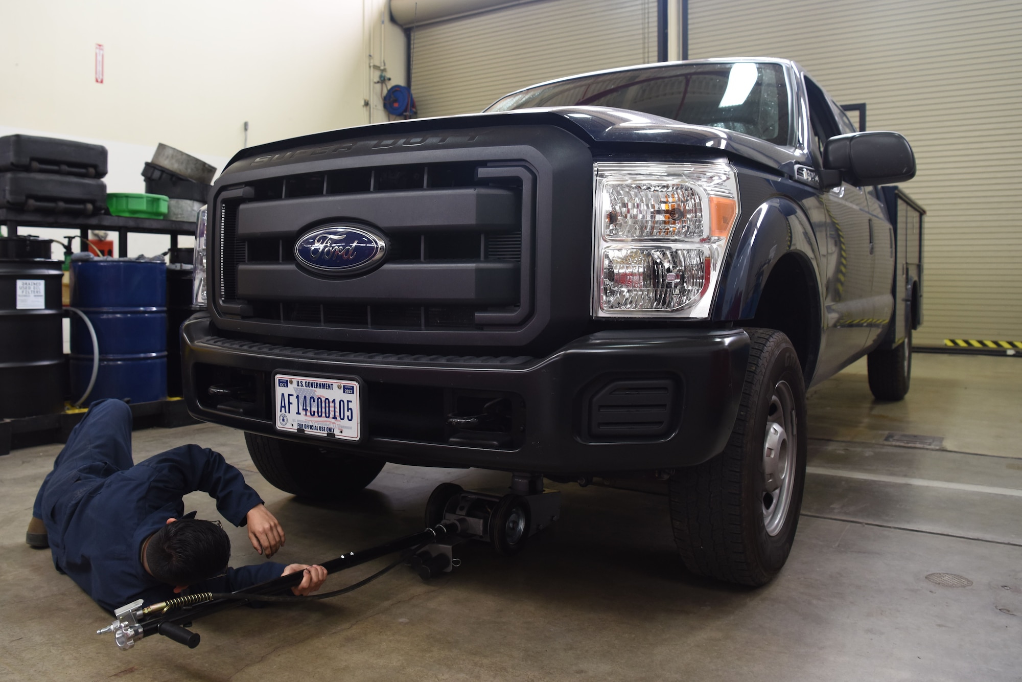 Airman 1st Class Jacobo Abeytia, 30th Logistics Readiness Squadron vehicle maintenance apprentice, places a jack underneath a vehicle during a routine tire change, May 29, 2018, at Vandenberg Air Force Base, Calif. Abeytia lifted the vehicle to begin the tire change. (U.S. Air Force photo by Airman Aubree Milks/Released)