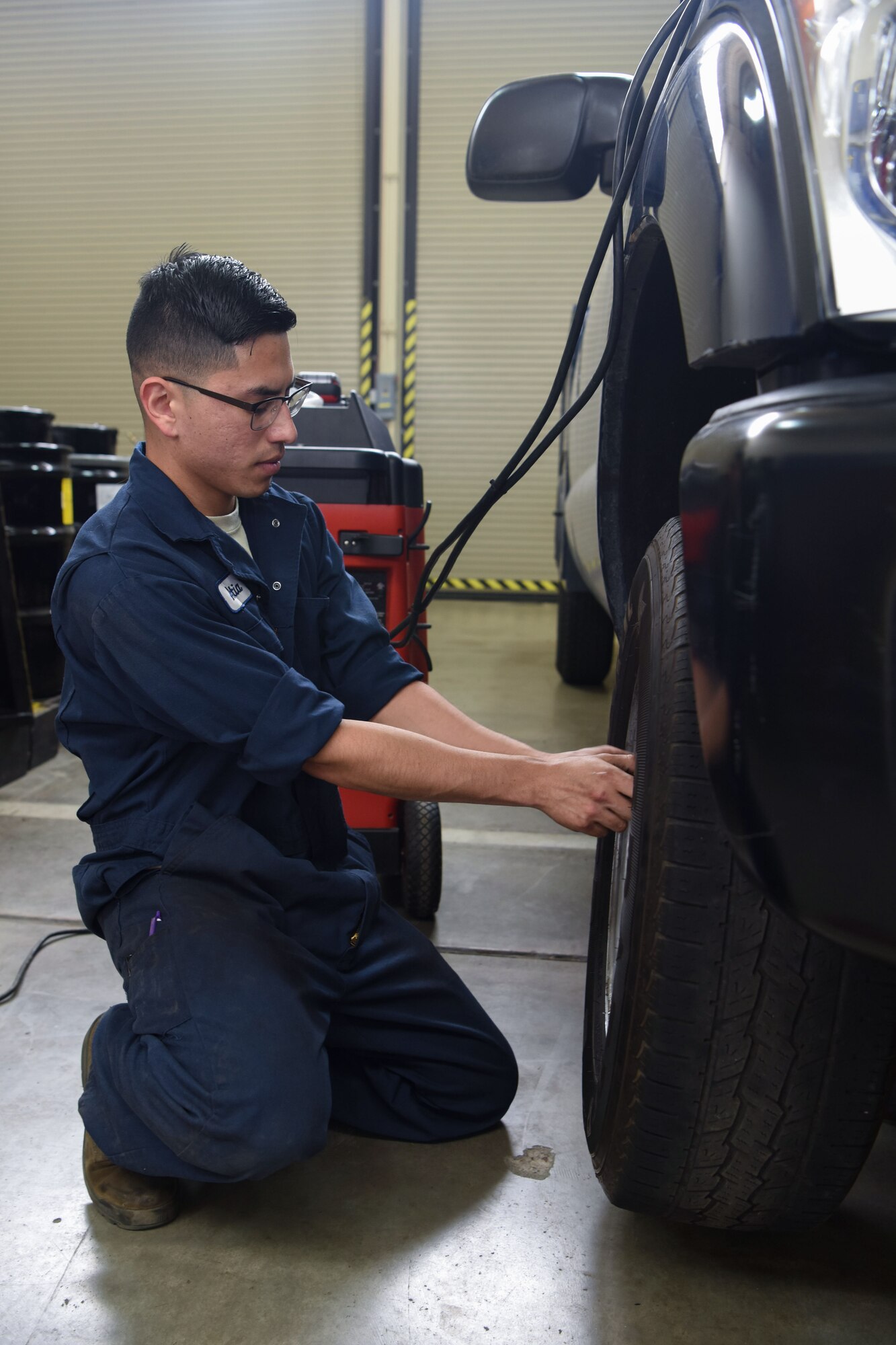 Airman 1st Class Jacobo Abeytia, 30th Logistics Readiness Squadron vehicle maintenance apprentice, places a tire on a vehicle during a routine tire change, May 29, 2018 at Vandenberg Air Force Base, Calif. A vehicle maintenance apprentice practices where an automobile is serviced on a regular basis to prevent a major breakdown or the need for major repair. (U.S. Air Force photo by Airman Aubree Milks/Released)