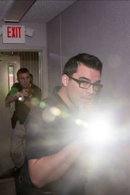 Kevin Bolton (front) and Thomas Zimmerman (back), patrol officers with the Provost Marshal’s Office, enter a building to search for an unknown person, who is possibly armed, during their annual use of force training on Marine Corps Base Camp Lejeune, May 25.