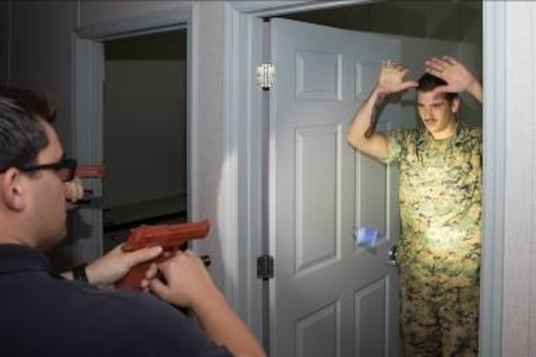 Seaman Apprentice Shawn McCoy, drops a training knife as Kevin Bolton, patrol officer with the Provost Marshal’s Office, locates him within a secured building during their annual use of force training on Marine Corps Base Camp Lejeune, May 25.