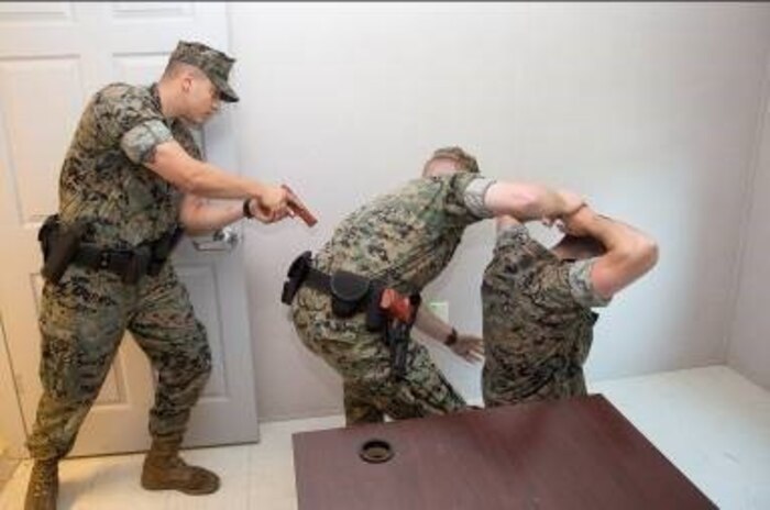 Military Police officers simulate arresting a suspect during the unsecured building sweep portion of their annual use of force training on Marine Corps Base Camp Lejeune, May 25.