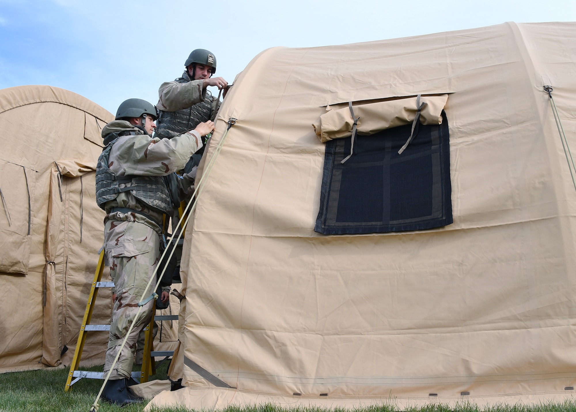 Airmen with the 319th Civil Engineer Squadron work together to erect shelter systems as part of a training June 1, 2018, on Fargo Air National Guard Base, North Dakota. The training allowed the Airmen to hone their skills and prepare them to build “tent cities” as they might on deployments. The 319 CES participated in a three-day mission essential equipment training, which allowed multiple crafts within the squadron to practice their war-time efforts. (U.S. Air Force photo by Airman 1st Class Elora J. Martinez)