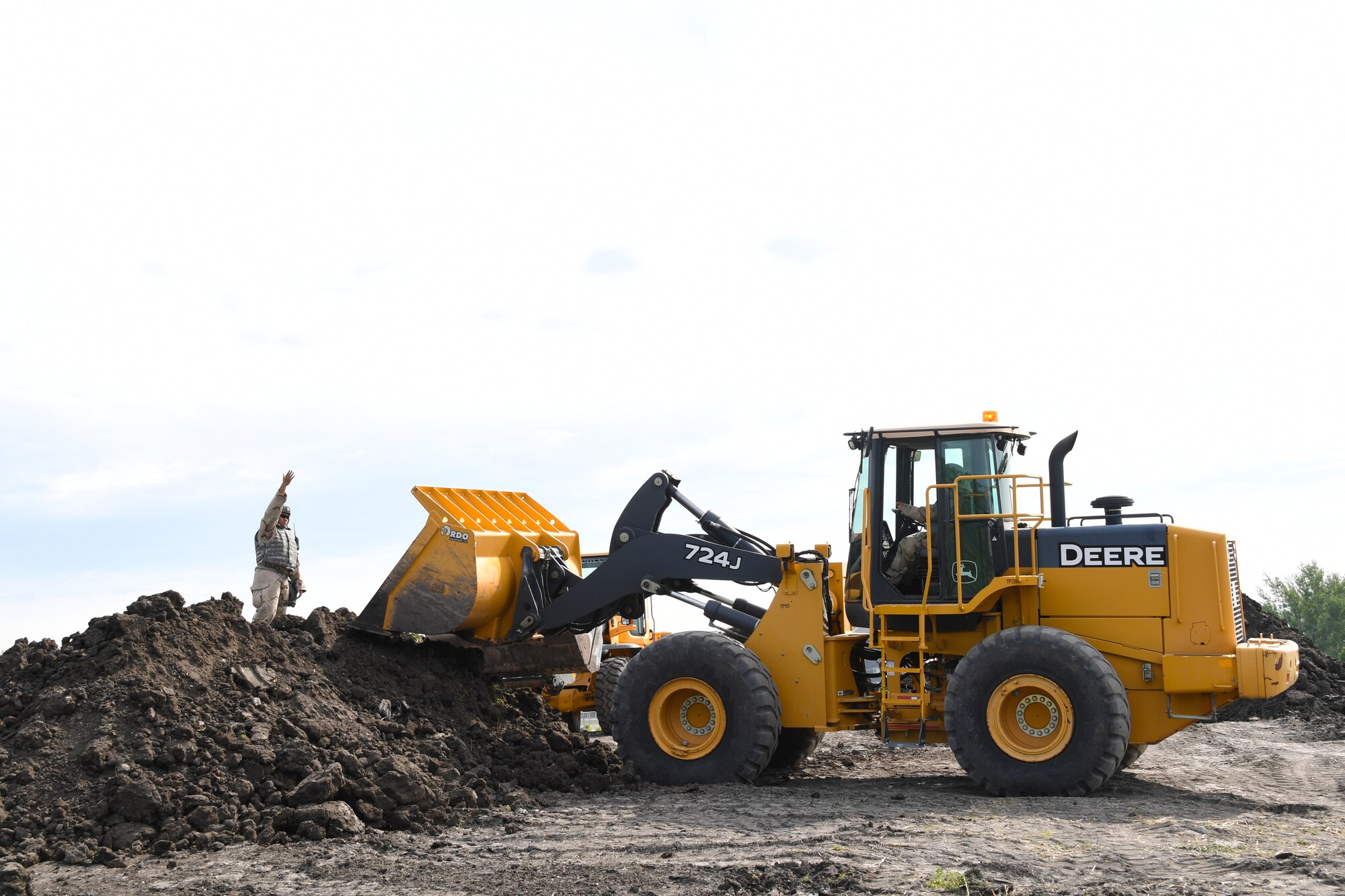Staff Sgt. Newington Tamaalii, pavements and equipment supervisor with the 319th Civil Engineer Squadron, directs a front-end loader as part of mission essential equipment training June 1, 2018, on Fargo Air National Guard Base, North Dakota. Tamaalii and his team were practiced building a fuel bladder containment berm with the help of the 319 CES execution support team. (U.S. Air Force photo by Airman 1st Class Elora J. Martinez)