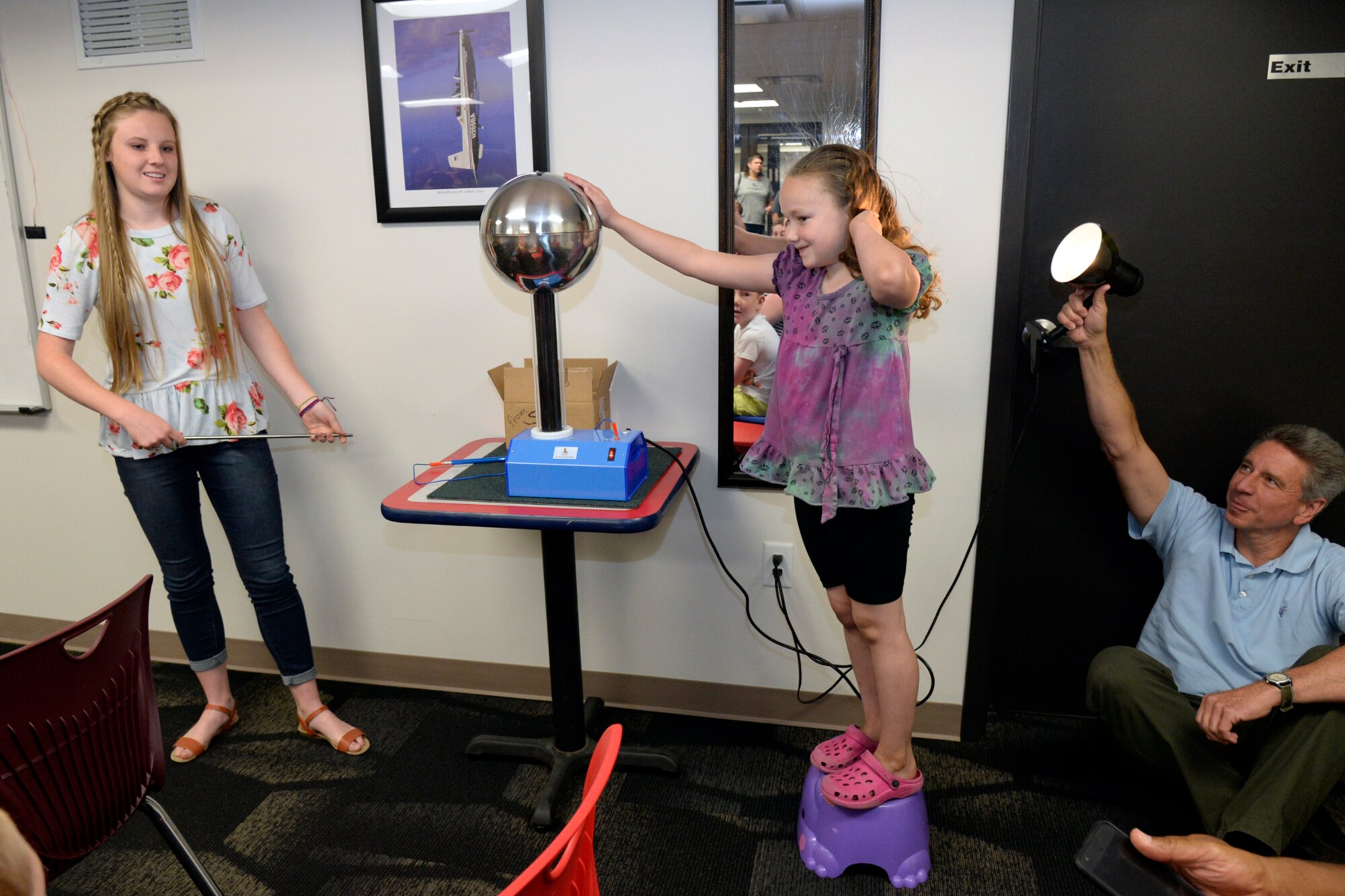 Rachel Griffin, a student summer intern at Hill Aerospace Museum, demonstrates electricity behavior to visitors with the
help of Kier Thomas, June 5, 2018, at Hill Air Force Base, Utah. (U.S. Air Force photo by Todd Cromar)