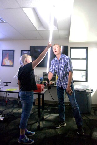 Tim Trimble, a student summer intern at the Hill Aerospace Museum, demonstrates electricity behavior to visitors with the
help of Meagan Degraw, June 5, 2018, at Hill Air Force Base, Utah. The museum is offering free classes related to science, technology, engineering and math through the summer to children at least 8 years of age. (U.S. Air Force photo by Todd Cromar)