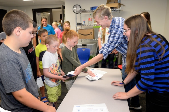Raelyn Johnstun and Tim Trimble, student summer interns at the Hill Aerospace Museum, give children participating in the
msueum's Summer STEM Passport Program a stamp in their passport books for attending class June 5, 2018, at Hill Air Force Base, Utah. When all their pages are stamped by attending all the classes, students will receive a special commemorative pin. The museum is offering free classes related to science, technology, engineering and math through the summer to children at least 8 years of age. (U.S. Air Force photo by Todd Cromar)