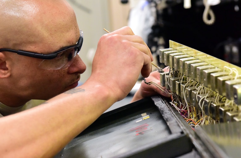 U.S. Air Force Tech. Sgt. Benjamin Sherrill, an Air Force Repair Enhancement Program technician assigned to the 509th Maintenance Group, cleans a damaged circuit board from a power control unit on May 29, 2018. It is worth $70,000 and is part of the munition lift trailer at Whiteman Air Force Base, Missouri. This type of repair can take from 24 hours to two weeks, depending on the level of damage. (U.S. Air Force photo by Staff Sgt. Danielle Quilla)