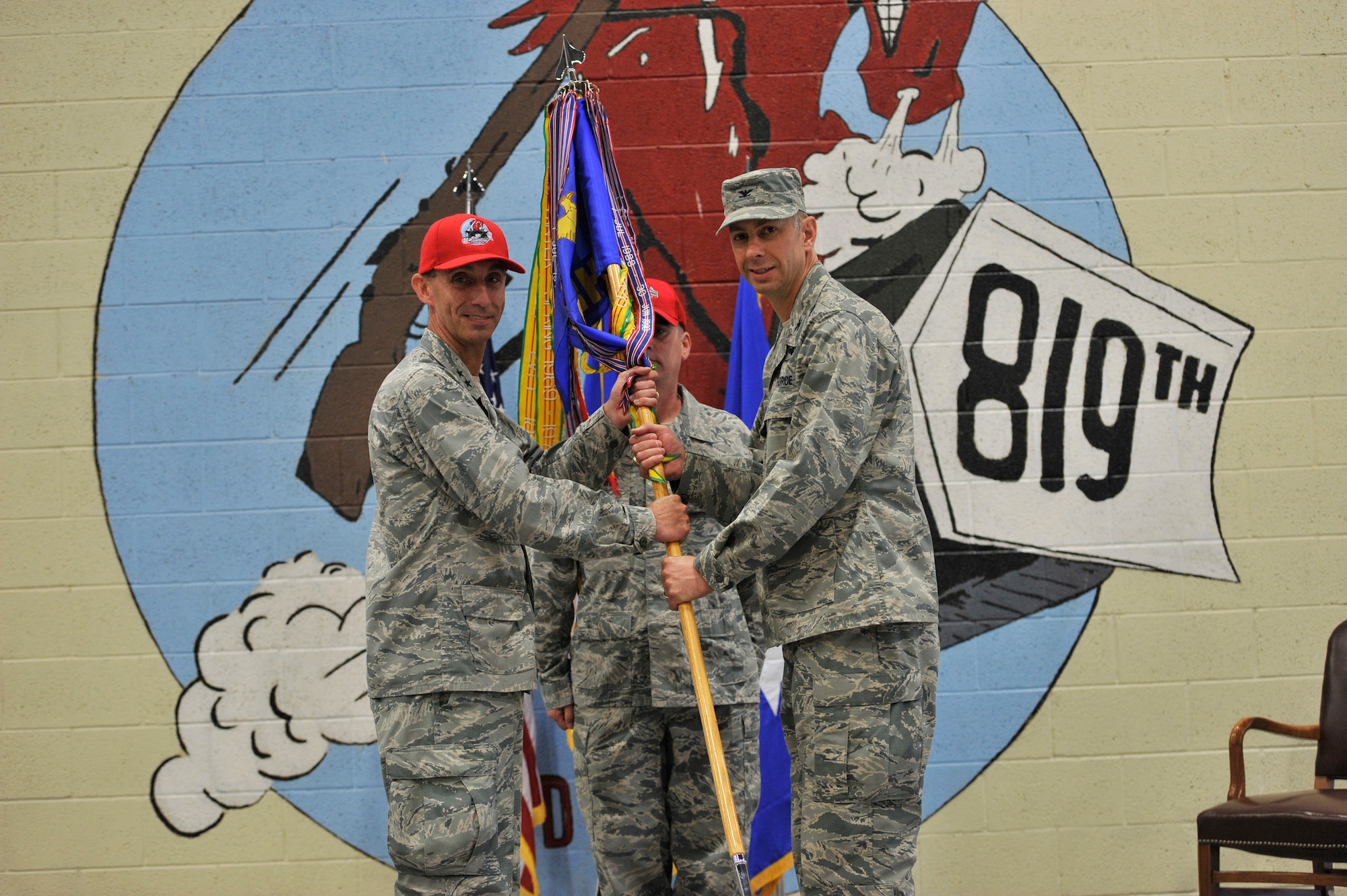U.S. Air Force Col. Jason Loschinskey, right, assumes command of the 819th Rapid Engineer Deployable Heavy Operational Repair Squadron Engineers (RED HORSE) from Maj. Gen. Scott J. Zobrist, 9th Air Force commander, as Senior Master Sgt. Craig Houchins, 819th RHS guidion bearer, looks on during a ceremony at Malmstrom Air Force Base, Mont., June 6, 2018. Loschinskey was previously the deputy commander for the 71st Mission Support Group at Vance AFB, Calif. The 819th RHS is a self-sufficient, 240-person mobile squadron capable of rapid response and independent operations in remote, austere environments worldwide.  (U.S. Air Force photo by John Turner)