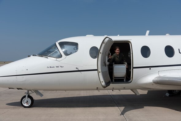 Col. Michelle Pryor, 47th Flying Training Wing vice commander, opens the entry door to the T-1 Jayhawk that bears her name at her fini-flight at Laughlin Air Force Base, Texas, May 31, 2018. Pryor retired with her husband, Lt. Col. David Pryor, 96th Flying Training Squadron instructor pilot, the next day on the same stage they both graduated specialized undergraduate pilot training on in class 99-05.