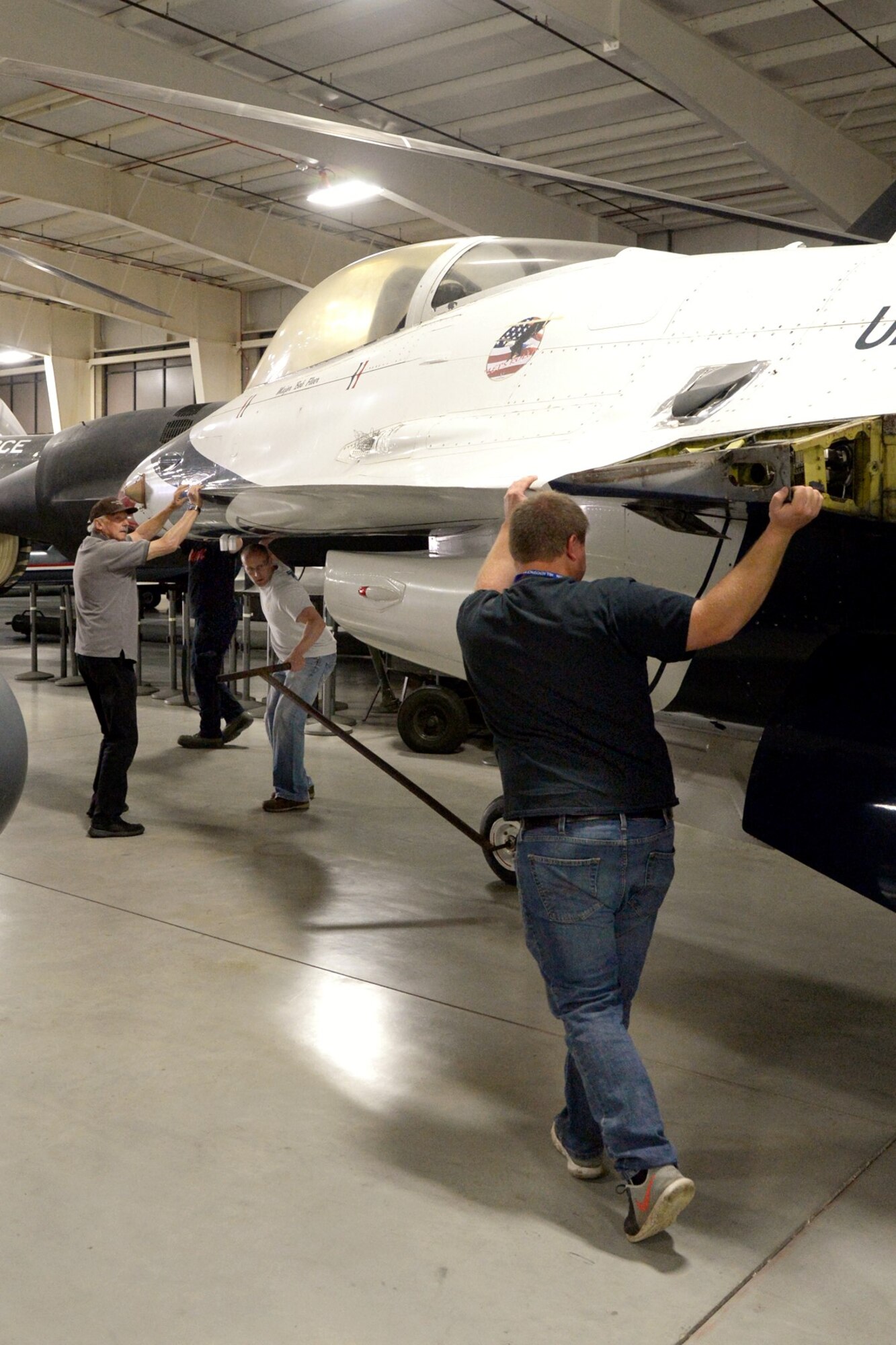 Hill Aerospace Museum staff and volunteers reposition a new additional static display aircraft May 20, 2018, at Hill Air Force Base, Utah. Now located at the east end of the museum’s fighter gallery, the former Thunderbird F-16A aircraft will be on display for visitors. (U.S. Air Force photo by Todd Cromar)