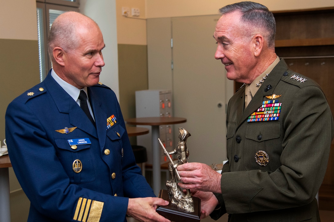 Marine Corps Gen. Joe Dunford presents a small statue to his Finnish counterpart.