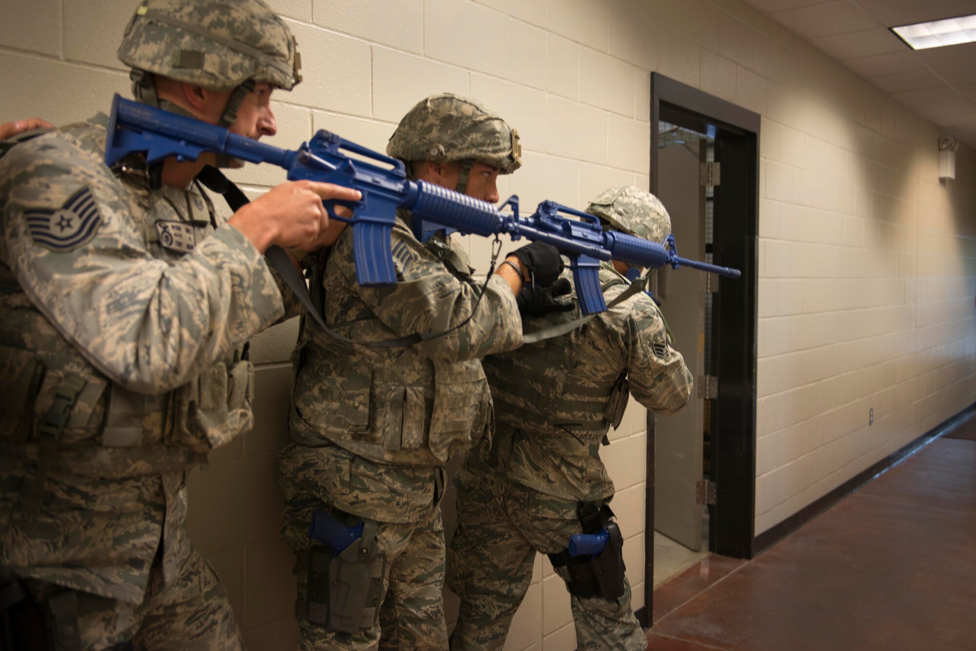 Tech. Sgt. Ryan Ball, Staff. Sgt. James Mcarthur and Tech. Sgt. Benjamin Rosengarden, 934th Security Forces Squadron fire team members, secure a hallway of the 934th SFS building as part of a room clearing training at Minneapolis Air Reserve Station, Minn., June 3, 2018. Room clearing training helps defenders sharpen skillsets that they could potentially use during a hostile situation. (U.S. Air Force Photo by Tech. Sgt. Amber E. N. Jacobs)