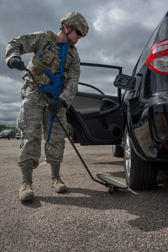 Staff Sgt. Robert Smolen, 934th Security Forces Squadron member, checks underneath of a vehicle during entry control point training at Minneapolis Air Reserve Station, Minn., June 3, 2018. Airmen from the 934th SFS conducted vehicle search as part of a quarterly training exercise to sharpen required job skills. (U.S. Air Force Photo by Tech. Sgt. Amber E. N. Jacobs)