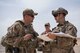 During an exercise, Staff Sgt. Daniel Fox (right), 332nd Expeditionary Civil Engineer Squadron Explosives Ordnance Disposal technician and team lead, asks Tech. Sgt. Douglas Pearce, 332nd Expeditionary Security Forces patrolman, about the possible improvised explosive device in a car at an undisclosed location in Southwest Asia, May 28, 2018.