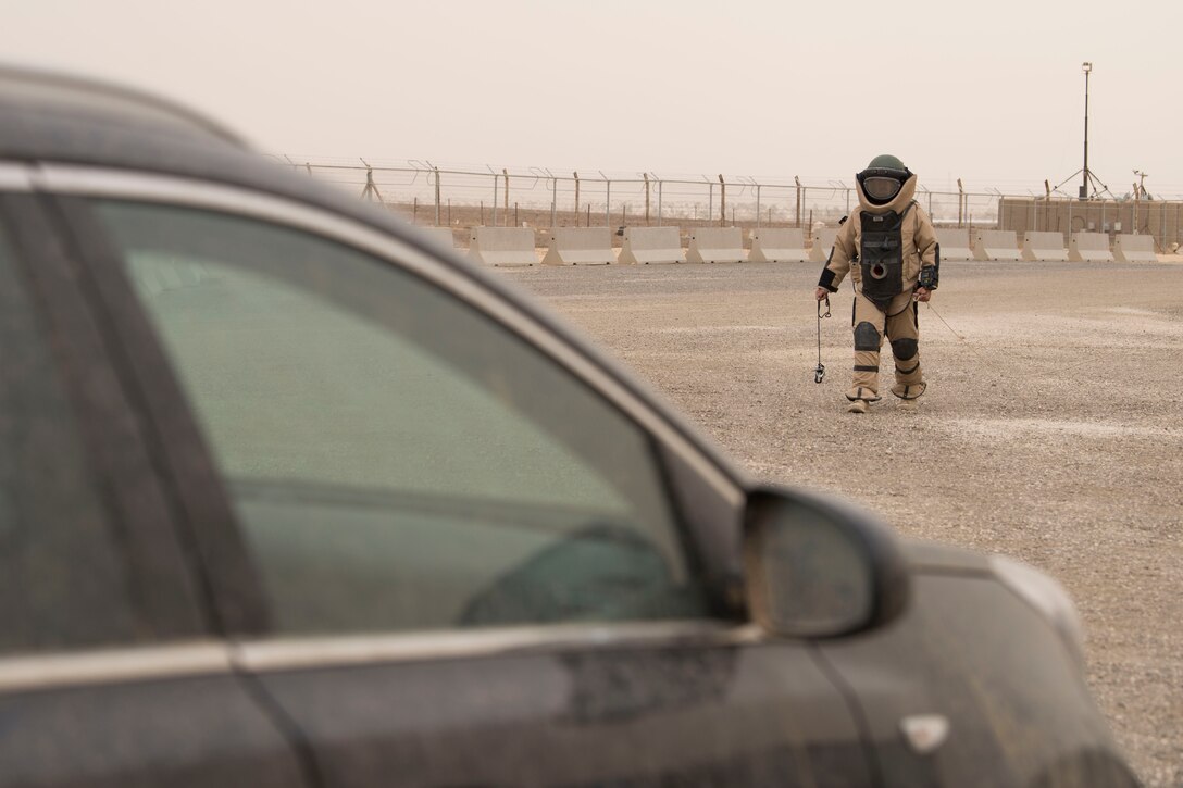 Staff Sgt. Daniel Fox, 332nd Expeditionary Civil Engineer Squadron Explosives Ordnance Disposal technician and team lead, approaches a car in a bomb suit to look for signs of a possible improvised explosive device during an exercise at an undisclosed location in Southwest Asia, May 28, 2018.