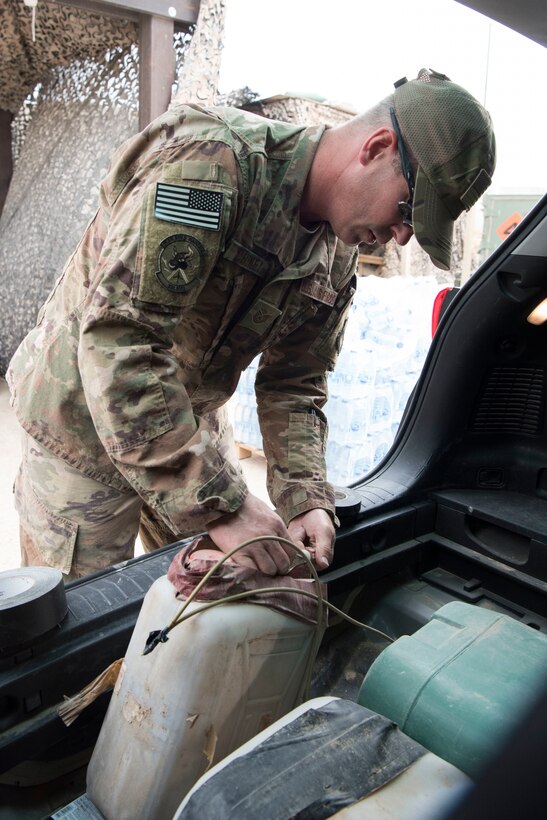 Tech. Sgt. Noah Cheney, 332nd Expeditionary Civil Engineer Squadron Explosives Ordnance Disposal unit NCO in charge of training, prepares an inert improvised explosive device hidden in a car in preparation for an exercise at an undisclosed location in Southwest Asia, May 28, 2018.
