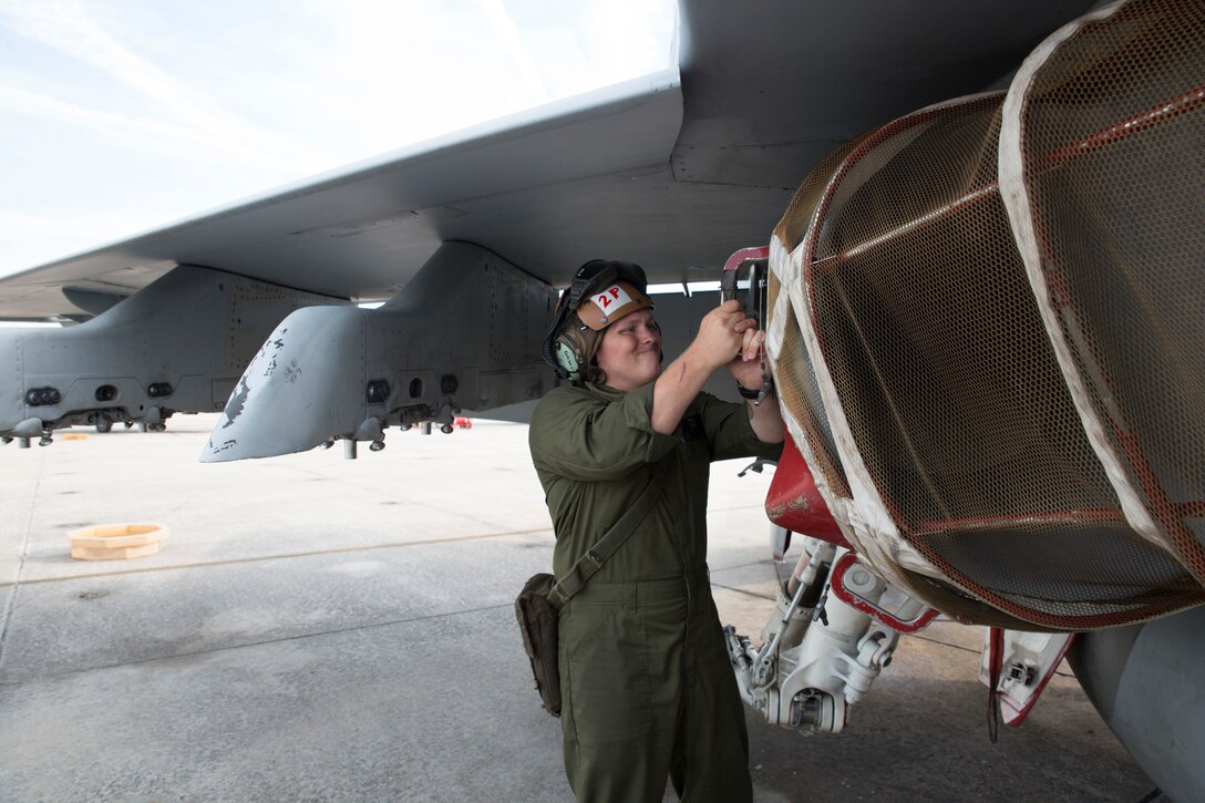 Lance Cpl. Hunter Cauthron places a screen over the engine intake of an F/A-18 Hornet aboard Marine Corps Air Station Beaufort June 6. The screen over the engine intake is used when Marines who are not pilots start the aircraft’s engines to conduct
pre-flight checks. It ensures foreign object debris does not enter the engine. Cauthron is an engine mechanic and plane captain with Marine Fighter Attack Squadron 312.