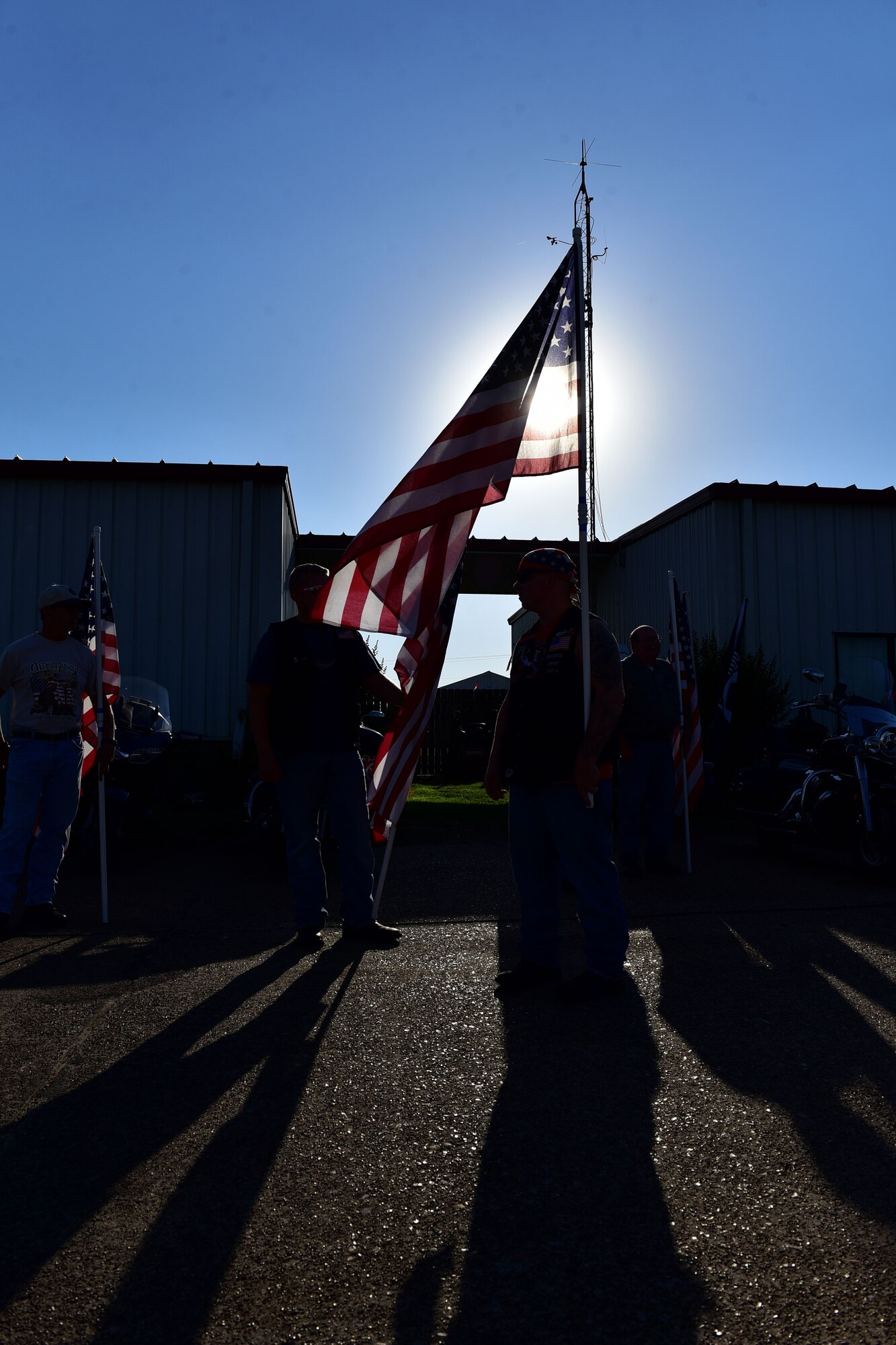 Men stand holding flags.